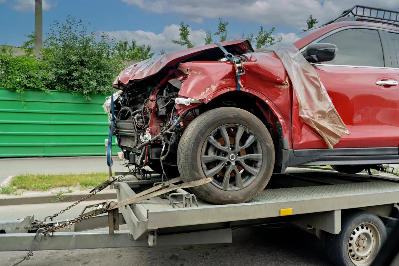 Damaged vehicle secured on a flatbed truck for an Oregon junk-car pickup