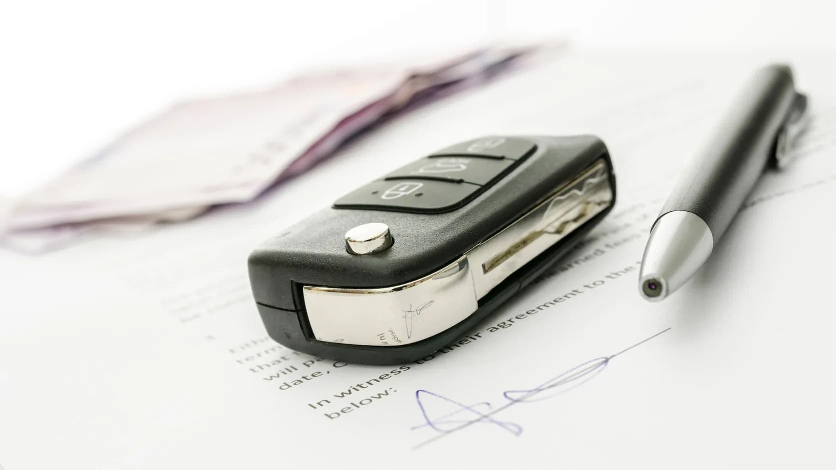 Car key and signed vehicle document illustrating an Oregon DMV Notice of Sale after a junk-car transaction