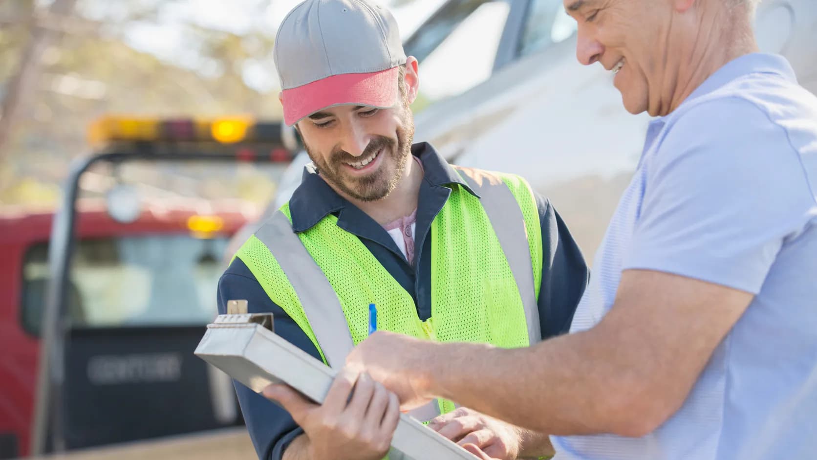 Oregon vehicle seller reviewing sale paperwork with a roadside towing professional before pickup