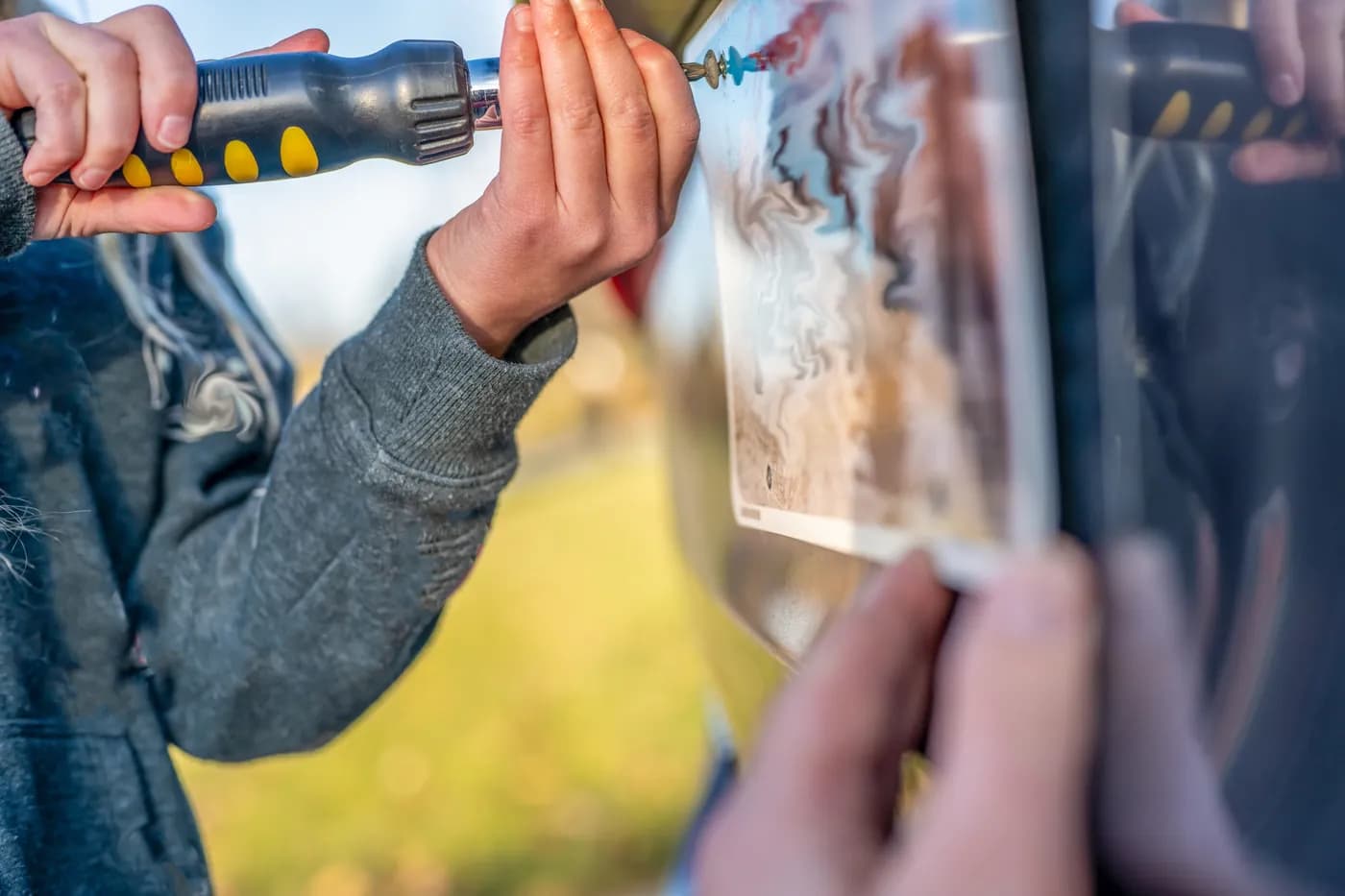 Person using a screwdriver on a rear vehicle license plate before an Oregon junk-car pickup