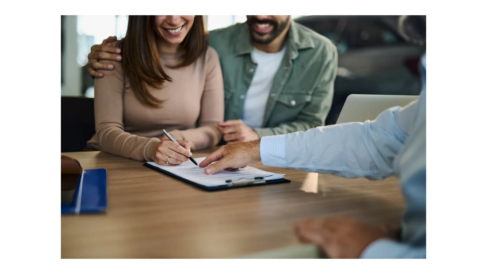 Two co-owners reviewing an Oregon vehicle title before selling a car
